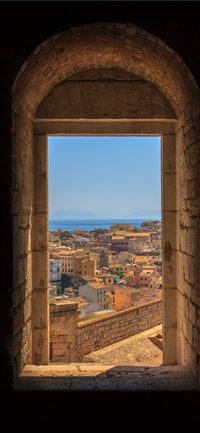view of concrete buildings from window during dayt... wallpaper