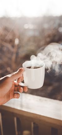 person holding white ceramic cup with hot coffee wallpaper