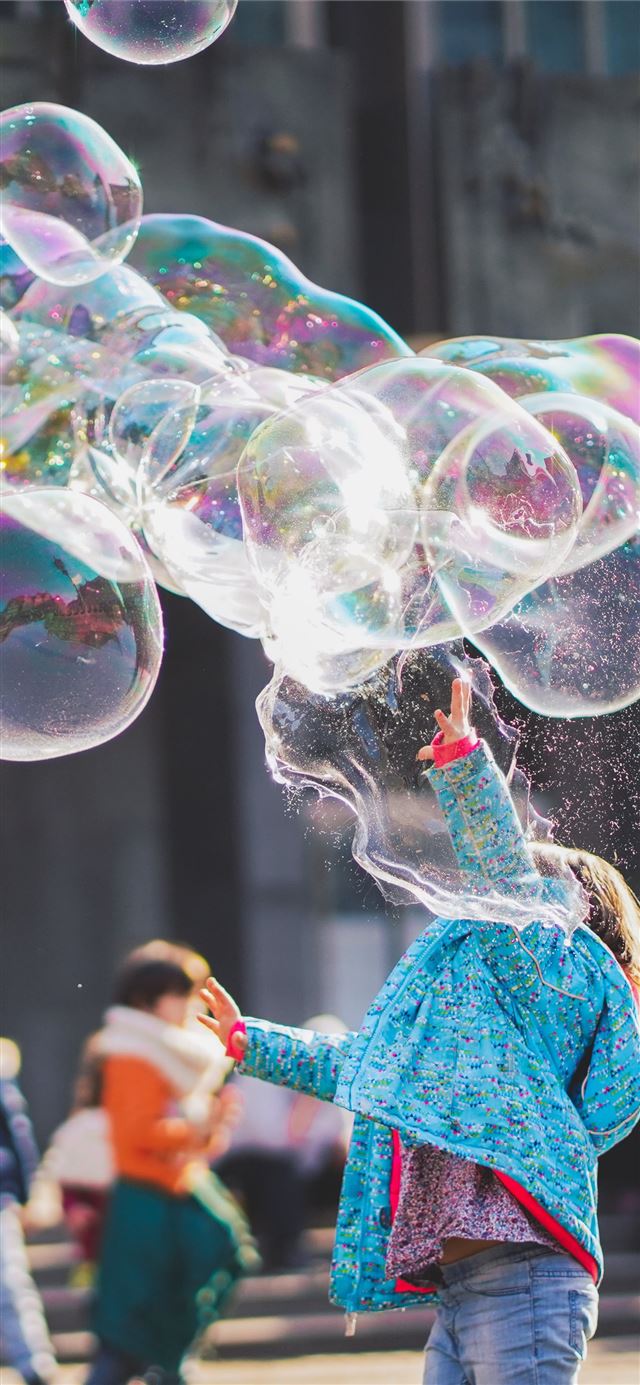 woman blowing bubbles iPhone 12 wallpaper 