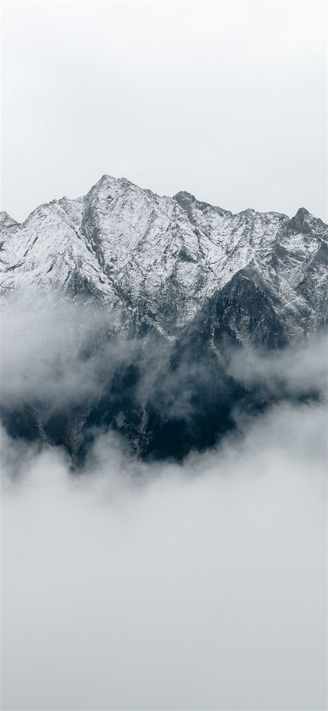 gray mountain covered in fog during daytime iPhone 12 wallpaper 