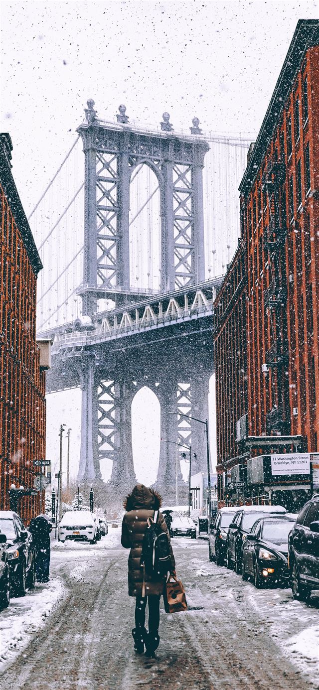 woman facing towards Brooklyn Bridge in New York iPhone 12 wallpaper 