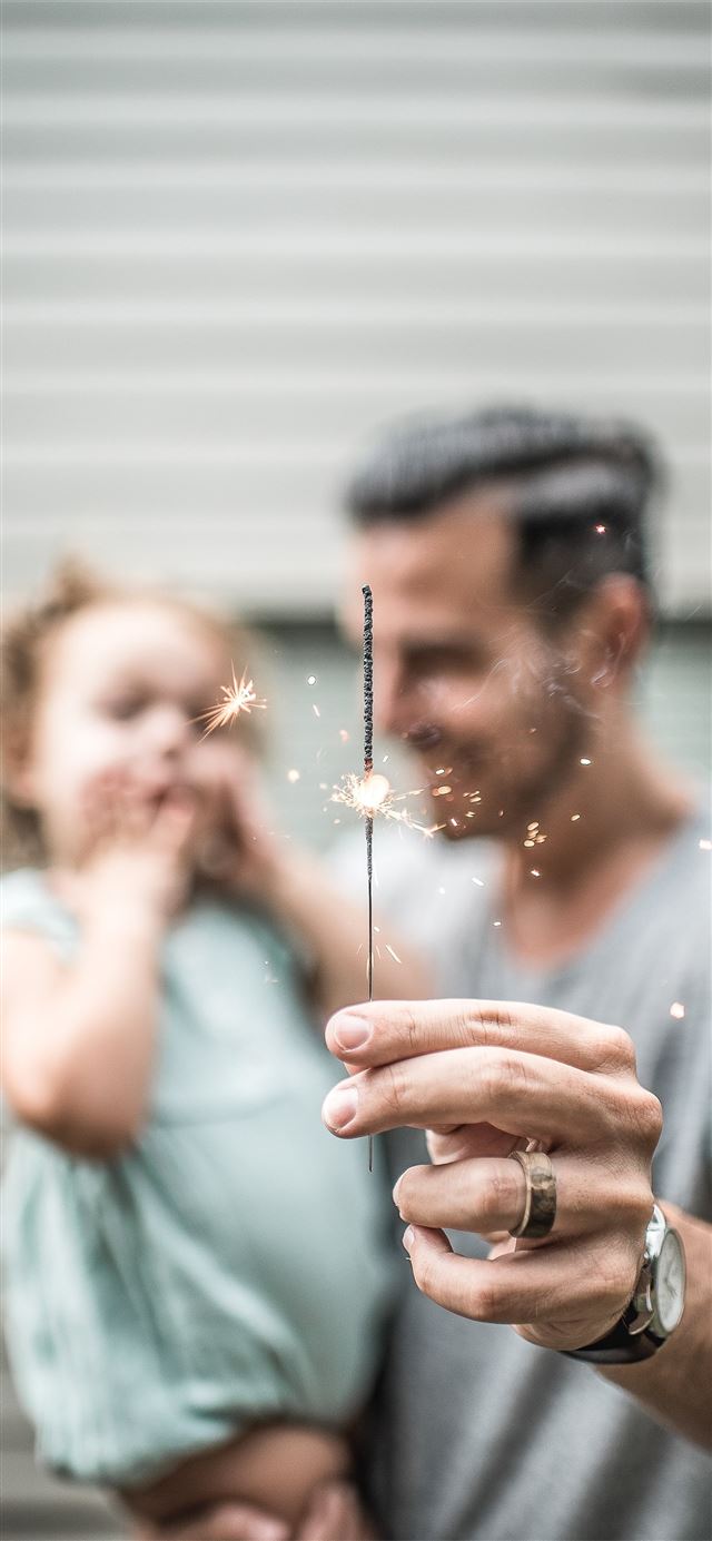 person holding sparklers iPhone 12 wallpaper 