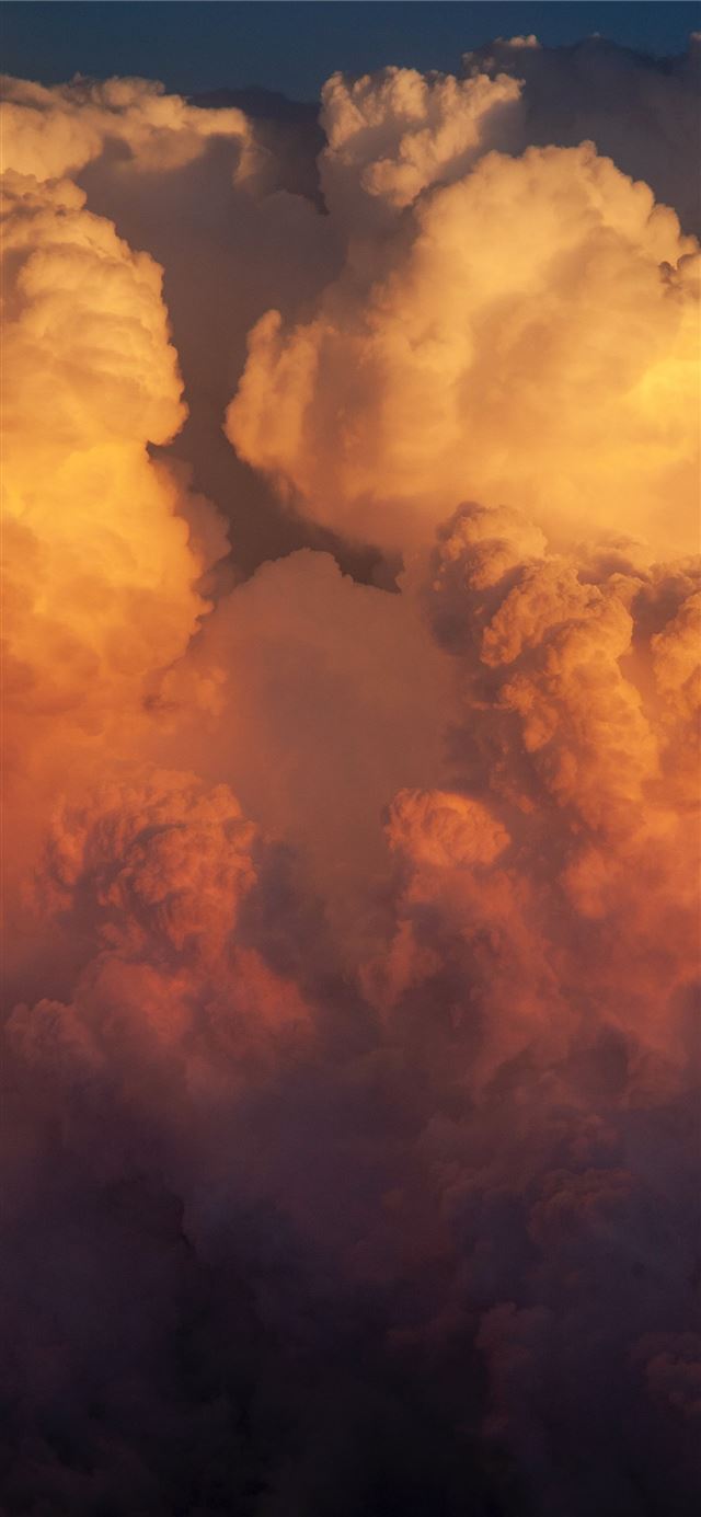 thick cloud formation during golden hour iPhone 12 wallpaper 