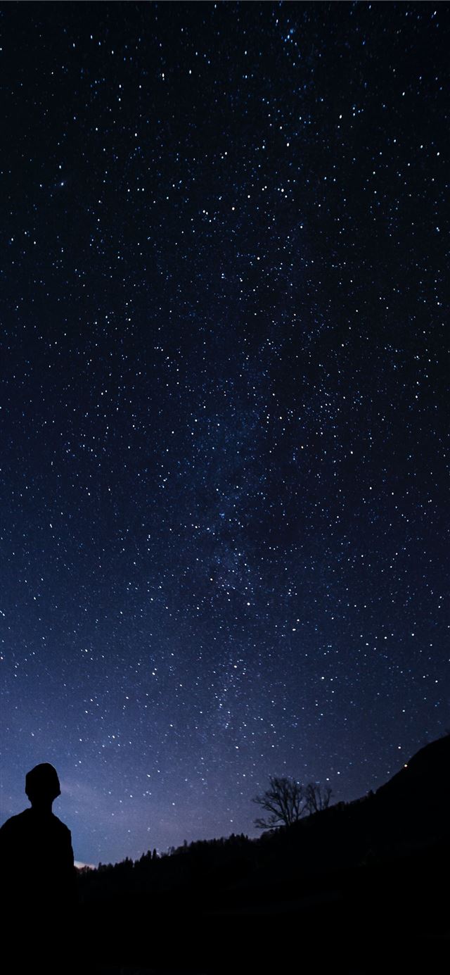 silhouette of man looking at milky way iPhone 12 wallpaper 