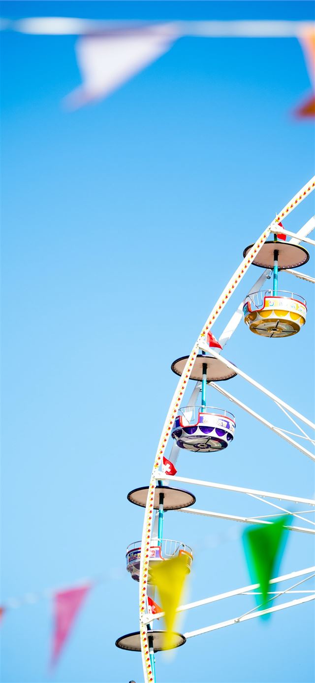 white and yellow Ferris wheel under blue skies pho... iPhone 12 wallpaper 