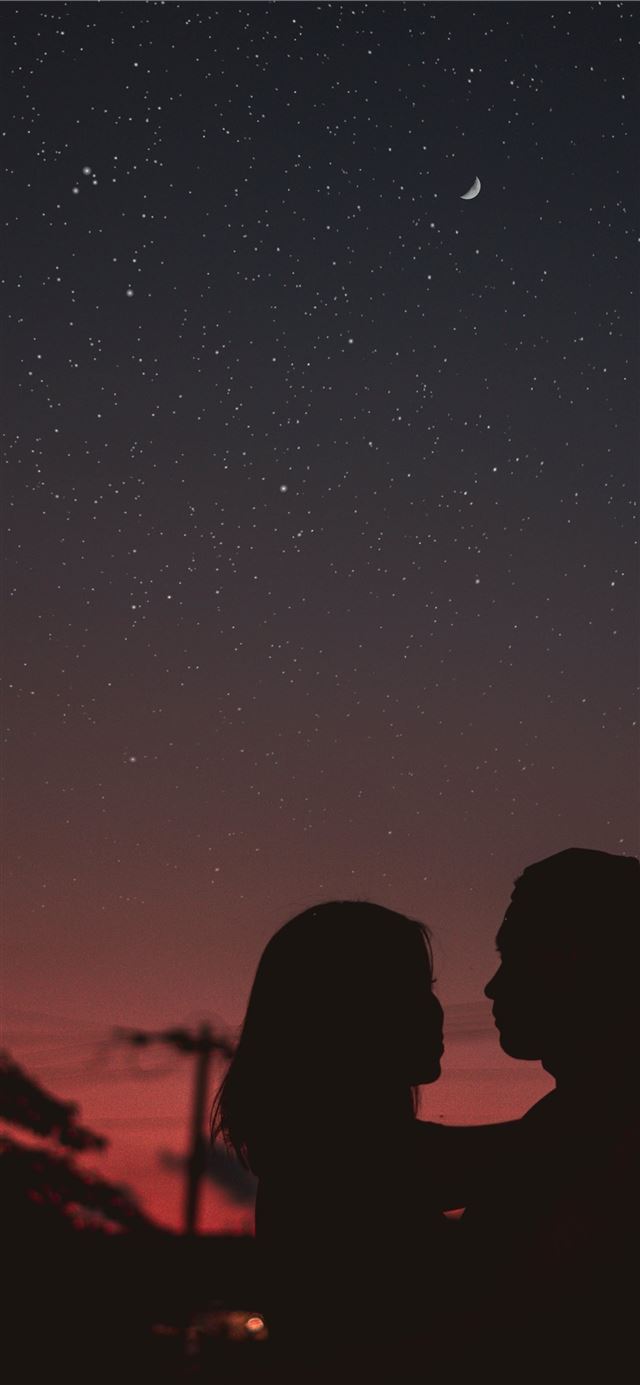 silhouette of woman hugging mna under starry night... iPhone 12 wallpaper 