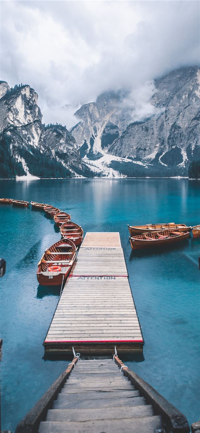 boat on body of water near mountains iPhone 12 wallpaper 