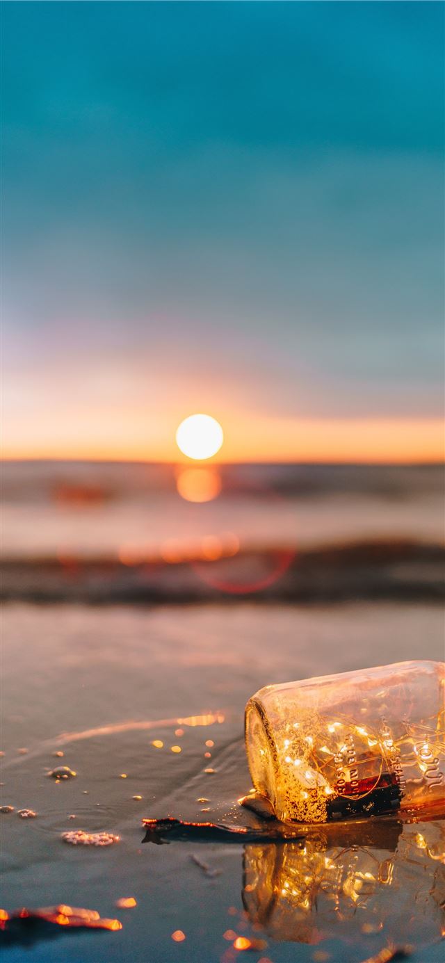 clear glass mason jar on beach during sunset iPhone 12 wallpaper 