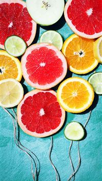 assorted fruit slices decor on teal surface wallpaper