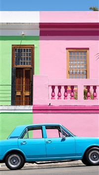 blue sedan parked beside pink and green house wallpaper