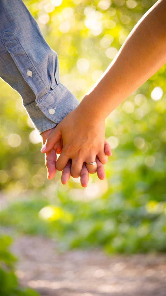1080x1920 shallow focus photo of man and woman holding hands - orange iPhone 8 Wallpaper
