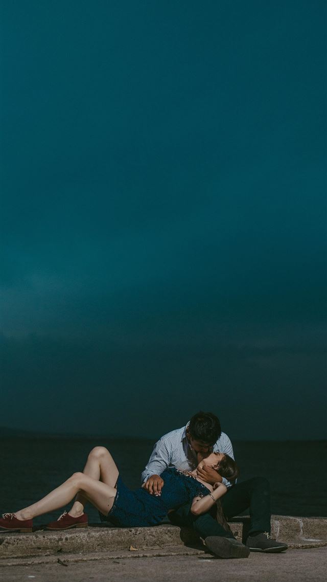 1284x2778 man kissing woman while sitting on railings during... -  iPhone 8 Wallpaper