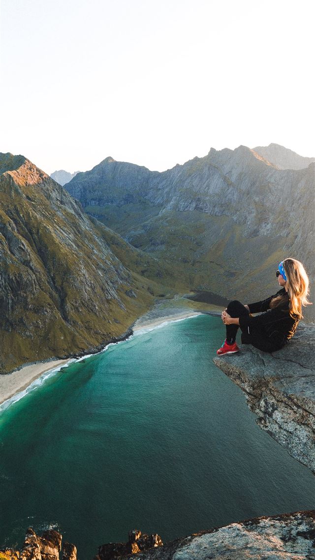 1284x2778 woman sitting on cliff overlooking body of water n... - lofoten iPhone 8 Wallpaper