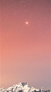 snow covered mountain under blue sky with stars du... wallpaper