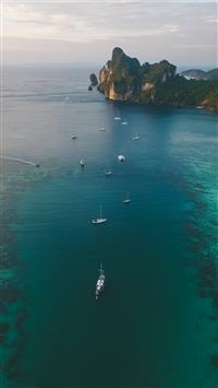 white boats on ocean water under gray sky wallpaper