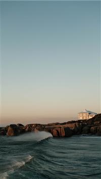 white and brown house on brown rock formation near... wallpaper
