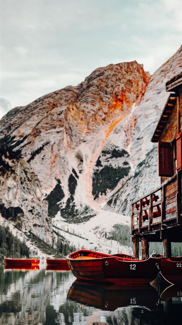 1080x1920 red boat on body of water near brown wooden house ... - lago di braies iPhone 8 Wallpaper