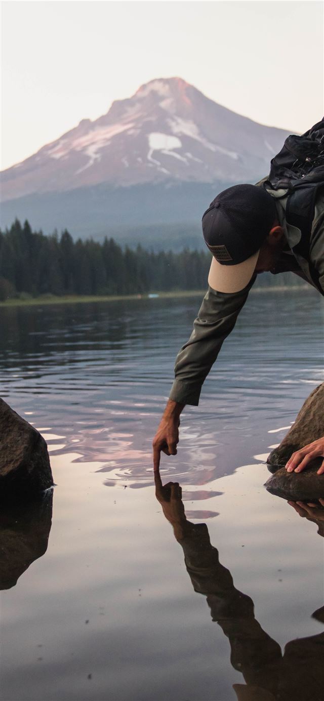 1080x1920 man putting finger on water viewing mountain -  iPhone SE Wallpaper