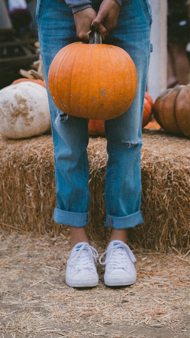640x1136 woman carrying pumpkin while standing beside hay - thanksgiving iPhone Wallpaper
