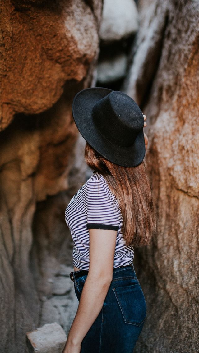 640x1136 woman standing between narrow cave pathway - united states iPhone Wallpaper