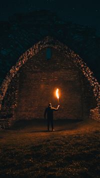 person holding torch in building interior wallpaper