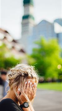 person covering face with hands outdoors wallpaper