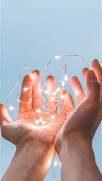person holding string lights wallpaper