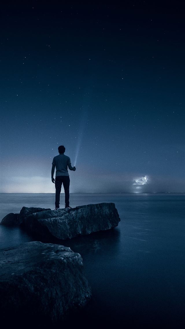 640x1136 man holding flashlight standing on rock - canada iPhone Wallpaper