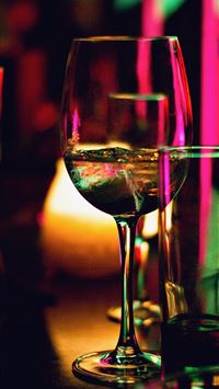 half filled wine glass beside half empty clear pin... wallpaper