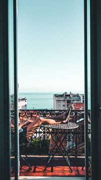 person sitting on balcony wallpaper