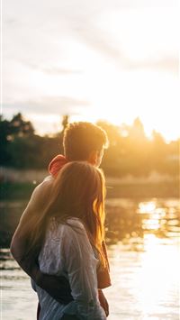 couple walking on lake side watching sunset close ... wallpaper