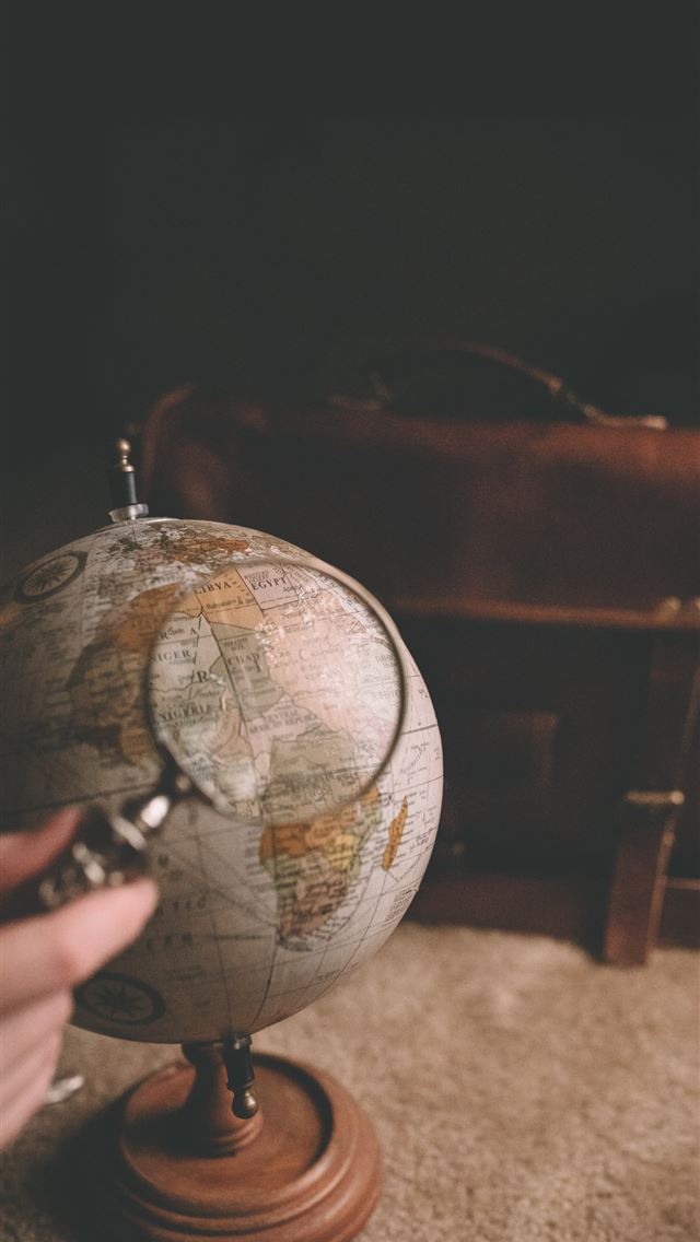 640x1136 person holding magnifying glass near desk globe - earth iPhone Wallpaper