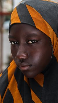 girl in black and orange striped head scarf in sel... wallpaper
