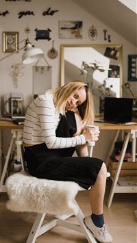 woman sitting on stool resting her head on her kne... wallpaper