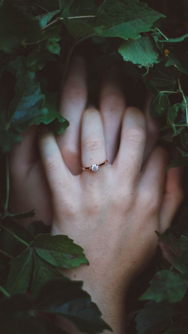 1284x2778 gold colored ring on hands surrounded by green lea... - diamond iPhone Wallpaper