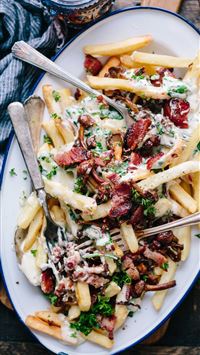 bacon strips and melted cheese topped fries on ova... wallpaper