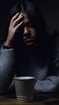 woman in gray sweater seating on chair wallpaper
