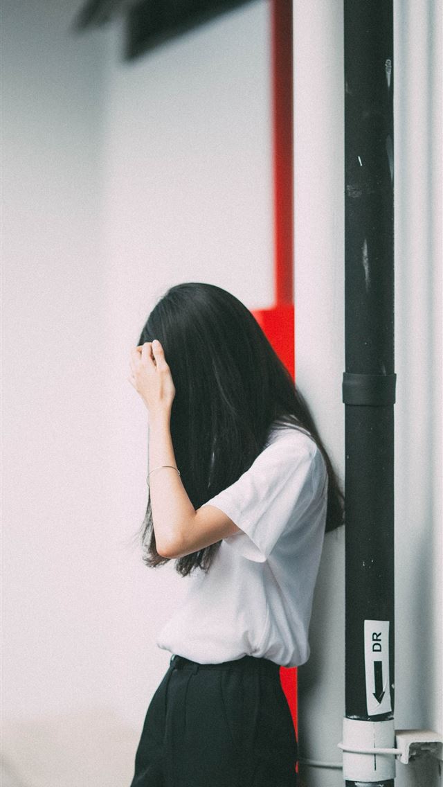 1284x2778 woman leaning on white concrete wall - thailand iPhone Wallpaper