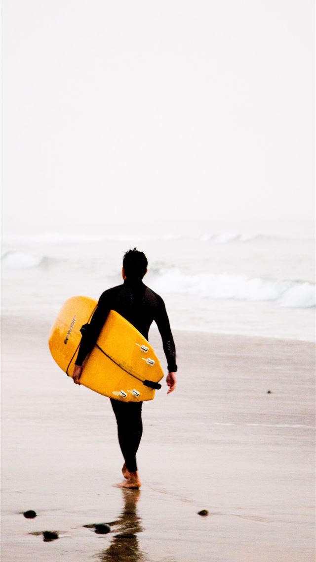 1284x2778 man holding yellow surfboard while walking on seas... - carlsbad iPhone Wallpaper