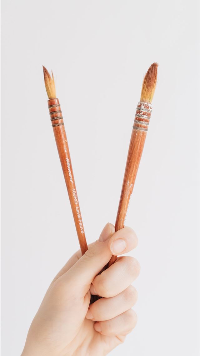 1284x2778 person holding two brown brushes - creative iPhone Wallpaper