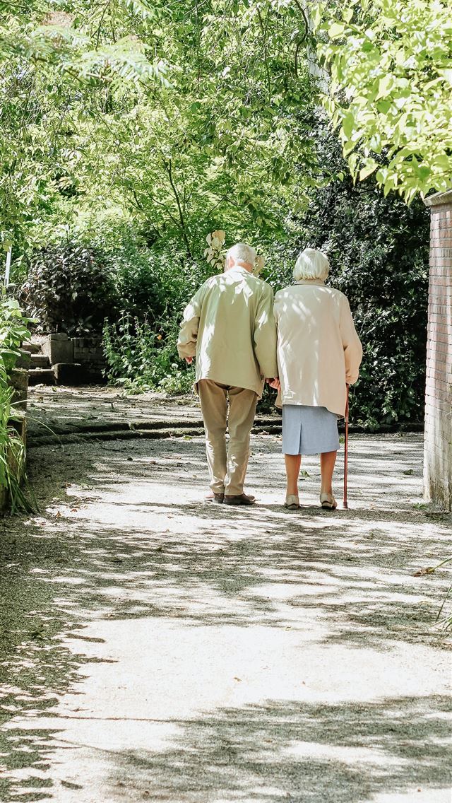 1284x2778 man and woman walking on road during daytime - rotterdam iPhone Wallpaper