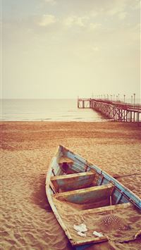 blue canoe boat on brown sand near brown wooden do... wallpaper