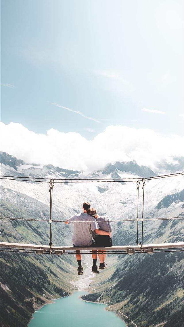1284x2778 man and woman sitting on hanging bridge at daytime -  iphone 13 Wallpaper