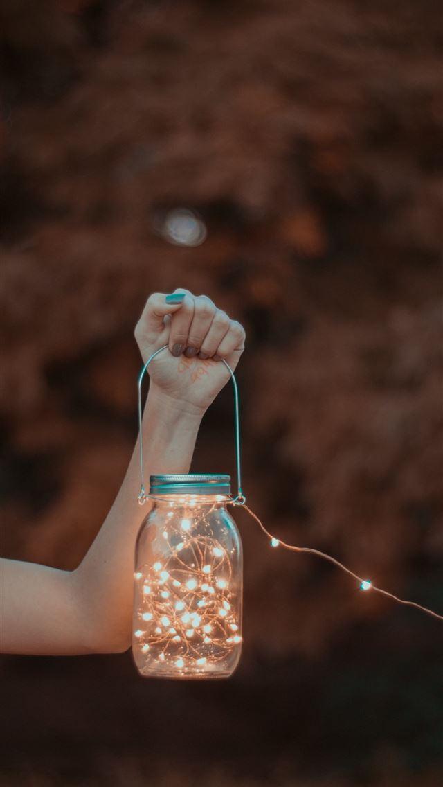 1284x2778 person holding mason jar with string lights -  iphone 13 Wallpaper
