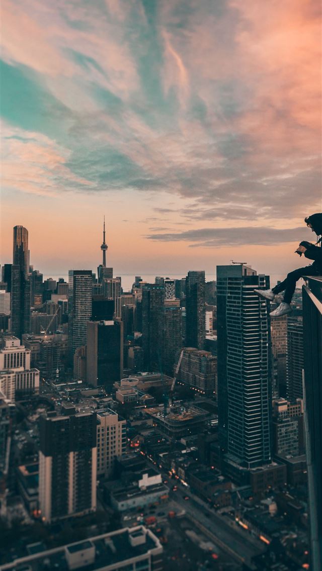 1284x2778 person sitting on top of the building - city iPhone Wallpaper