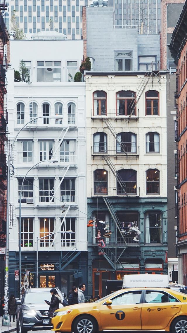1242x2688 yellow sedan on road near buildings with people wa... -  iphone 13 Wallpaper
