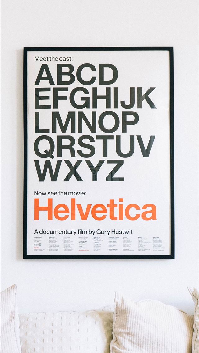 1284x2778 wall mounted Helvetica alphabet poster above sofa - design iPhone Wallpaper