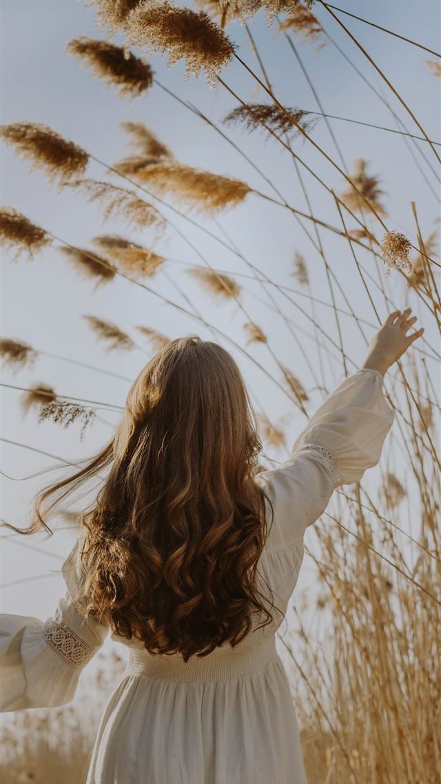 1284x2778 woman in white long sleeve shirt standing on brown... - spring iPhone Wallpaper