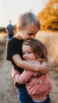 boy in black t shirt hugging girl in red and white... wallpaper