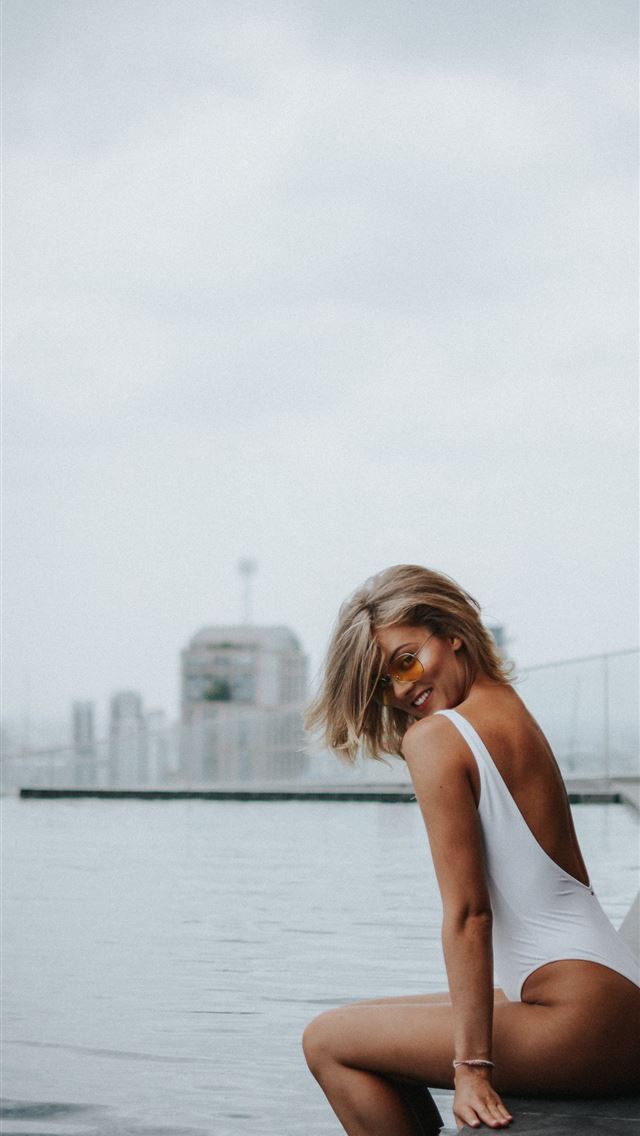 1284x2778 woman sitting beside pool under cloudy sky during ... - girls iPhone Wallpaper